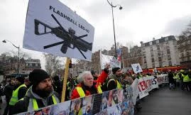 Người biểu tình 'Áo vàng' mang theo biểu ngữ phản đối, cùng ảnh của các nạn nhân bị thương khi đụng độ với cảnh sát