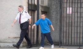 đối tượng Lê Trung Dũng đang bị cảnh sát áp tải (Ảnh: The Scottish Sun)