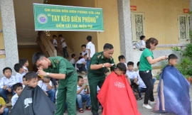 Chi đoàn Đồn Biên phòng Cửa Lân phối hợp với Đoàn thanh niên xã Nam Thịnh cắt tóc miễn phí cho các em học sinh trường tiểu học xã Nam Thịnh, huyện Tiền Hải. Ảnh: Văn Cương
