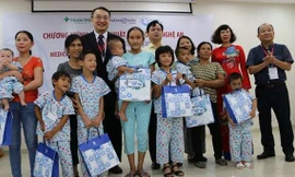 Đại diện Nhà tài trợ và Ban tổ chức trao quà cho các trẻ em có hoàn cảnh đặc biệt khó khăn. 