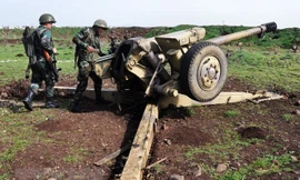 Binh sỹ Chính phủ Syria kiểm tra các khẩu đội pháo đặt tại khu vực giữa Talbiseh và Rastan ở ngoại ô thành phố Homs, Syria. (Nguồn: AFP/TTXVN)