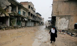 Một người phụ nữ di chuyển khó nhọc trong thành phố Mosul tan hoang