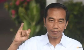 Tổng thống Indonesia Joko Widodo giơ ngón tay in mực sau khi bỏ phiếu tại thủ đô Jakarta