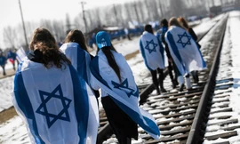 Người Israel choàng quốc kỳ lên người trong khi diễu hành trên đường ray ở trại diệt chủng Auschwitz khét tiếng của Phát xít Đức