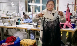 Chị Chen Haili bên chiếc áo ngủ vừa may xong. (Ảnh: SCMP)