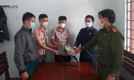 Anh Lê Văn Chung (thứ 2 từ phải sang) bàn giao số tiền nhặt được cho người mất - ảnh Huyền Oanh 