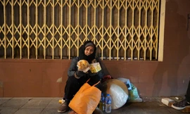 Một cụ bà không nhà cửa phải co ro trong đêm đông Hà Nội.