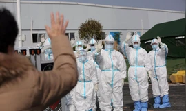 Các nhân viên y tế vẫy tay chào một bệnh nhân được ra viện ngày 1/3, sau khi điều trị tại bệnh viện Lôi Thần Sơn ở Vũ Hán. (Ảnh: China Daily)