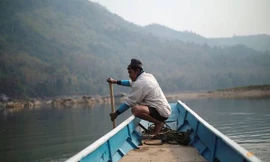 Một người dân Lào chèo thuyền ở khúc sông dự kiến sẽ được xây đập thủy điện ở Luang Prabang. (Ảnh: Reuters)