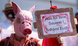 Một người biểu tình phản đối bên ngoài cuộc họp báo ở Gütersloh ngày 21/6. (Ảnh: CNN)