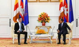 Thủ tướng Campuchia Hun Sen (phải) không đeo khẩu trang khi tiếp Ngoại trưởng Hungary. (Ảnh: AP)