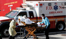  Một bệnh nhân được vận chuyển từ Trung tâm bệnh viện Elmhurst, Mỹ, ra xe cứu thương ngày 7/4. (Ảnh: AP) 