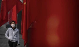 Một phụ nữ đeo khẩu trang khi đi bộ ở Bắc Kinh dịp Tết âm lịch vừa qua. (Ảnh: CNN)