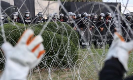 Người biểu tình cố kéo đổ hàng rào dây thép gai khi biểu tình trước Trung đoàn bộ binh số 11. (Ảnh: Reuters)