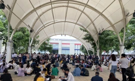 Phụ huynh, thí sinh ngồi la liệt ở sân trường để lấy số. Ảnh HC