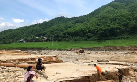 Cụ Nít cùng người thân ngồi bên nền nhà cũ bị lũ cuốn trôi, gọi tên các con đang mất tích. Ảnh: Hoàng Lam