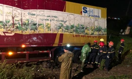 Sau tai nạn, cả tài xế và xe máy bị cuộn trong gầm container