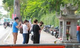 Sĩ tử và người dân kéo về vái lạy cầu may trước tấm "biển báo giao thông" ở Văn Miếu. Ảnh: Trọng Tài