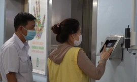 Người nuôi bệnh quét vân tay để vào khu nội trú.