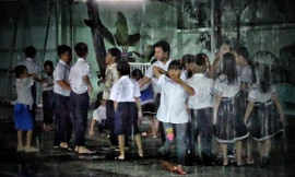 Các em phải đội mưa để đến trường làm lễ khai giảng.