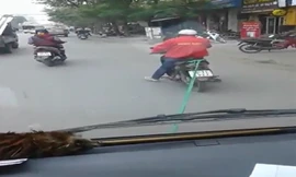 Xe máy kéo ôtô hết xăng đi trên phố Hà Nội