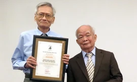 Ông Phan Trản - Đeo kính đang thay mặt gia đình Phan Khôi nhận giải thưởng từ tay nhà văn Nguyên Ngọc.