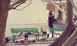 Hình ảnh ông bố che nắng cho con gái ngủ trên ghế đá "đốn tim" cư dân mạng. Ảnh: Facebook Bui Tuan Anh.