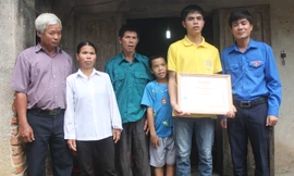 Anh Lê Văn Châu - phó bí thư Tỉnh đoàn Thanh Hóa (bìa phải) tặng bằng khen cho em Lê Hữu Hiếu sáng 9/7. Ảnh: Hoàng Lam.