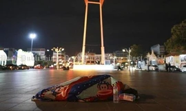 Một người vô gia cư đắp chăn trên đườg phố Bangkok trong cái lạnh 16 độ C - Ảnh: Patipat Janthong/ Bangkok Post 