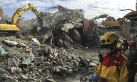 Lực lượng cứu hộ tìm trong đống đổ nát của khu chung cư sập. Ảnh: AP