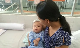 Bé Minh Phát trong vòng tay mẹ ngày xuất viện. 