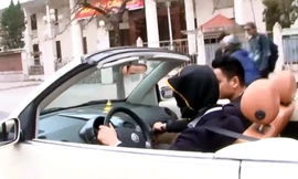 Người đàn ông trùm bao vải đen kín mặt, điều khiên ô tô trên phố Hà Nội. (Ảnh cắt từ clip)