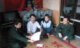 Cán bộ Phòng Chính trị thăm động viên HS nghèo vượt khó tại xóm Mát, xã Dân Chủ, Hòa Bình Ảnh: L.M.T