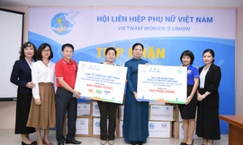 Chủ tịch Hội LHPN Việt Nam Hà Thị Nga (áo dài xanh), Phó Chủ tịch Hội Trần Thị Hương (kế bên trái), tiếp nhận phần hỗ trợ từ đại diện công ty Nestlé Việt Nam. 