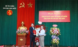 Đồng chí Đỗ Hoàng Anh Tuấn, Ủy viên Ban Cán sự Đảng - Thứ trưởng Bộ Tài chính trao Quyết định, tặng hoa chúc mừng đồng chí tân Tổng Giám đốc KBNN Nguyễn Đức Chi