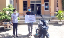 Em Nguyễn Trung Tính, một trong những nạn nhân bom mìn tại tỉnh Bình Định nhận xe máy và học bổng hỗ trợ từ Dự án KVMAP, một phần của chương trình hợp tác giữa UNDP và Bộ LĐ-TB&XH về khắc phục hậu quả bom mìn sau chiến tranh.