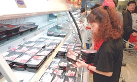 Người tiêu dùng lựa chọn thịt mát tại siêu thị