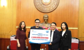 Ông Trần Vũ Hoài (thứ hai từ trái sang) – Giám Đốc Đối Ngoại công ty FrieslandCampina Việt Nam trao phần đóng góp cho đại diện Mặt trận Tổ Quốc Việt Nam