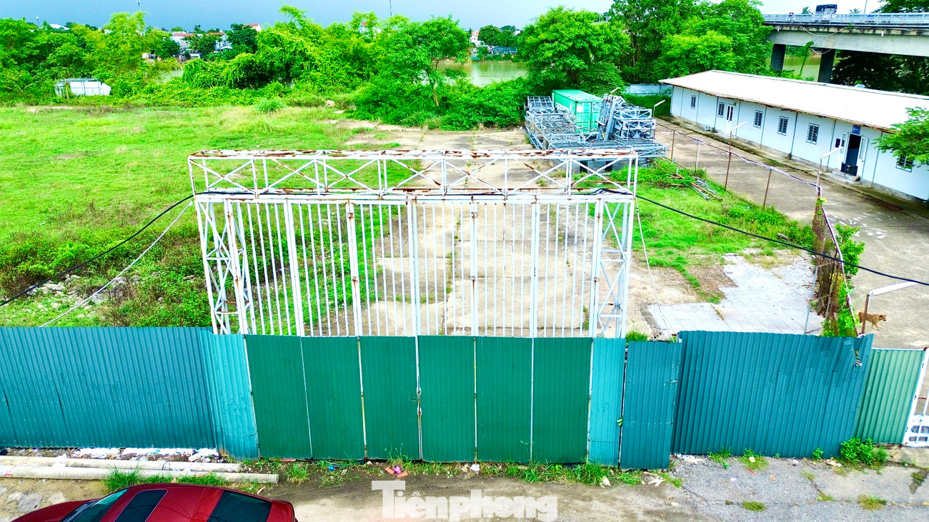 Bên ngoài, công trường bị quây tôn kín mít, khu đất dự án um tùm cỏ dại và cây bụi.