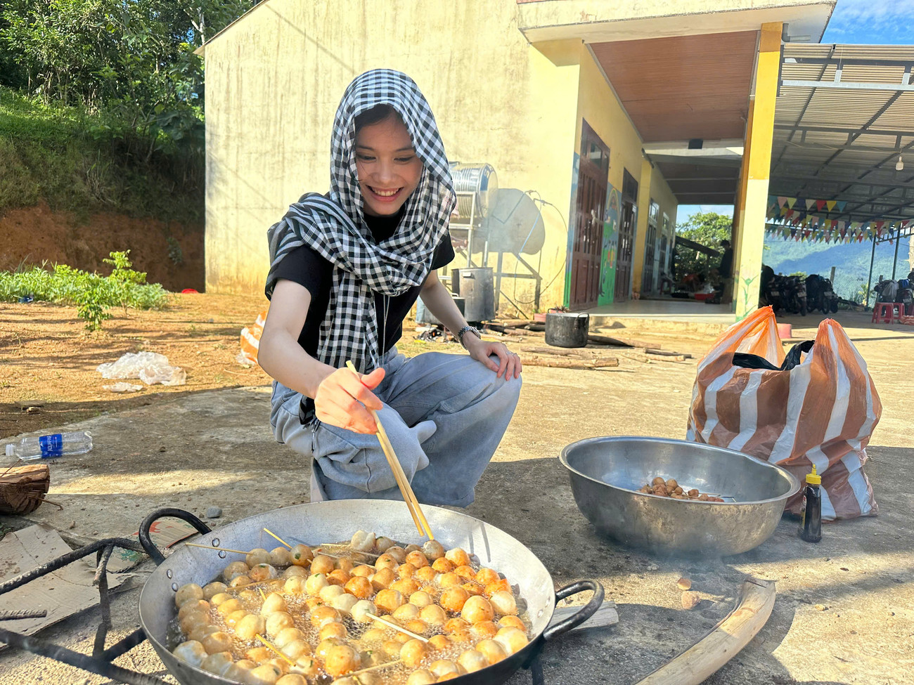 Không chỉ tặng quà, các tình nguyện viên còn chuẩn bị bữa ăn với hàng xâu cá viên chiên, hàng chục tô xương hầm rau củ quả gửi đến người dân trong làng.