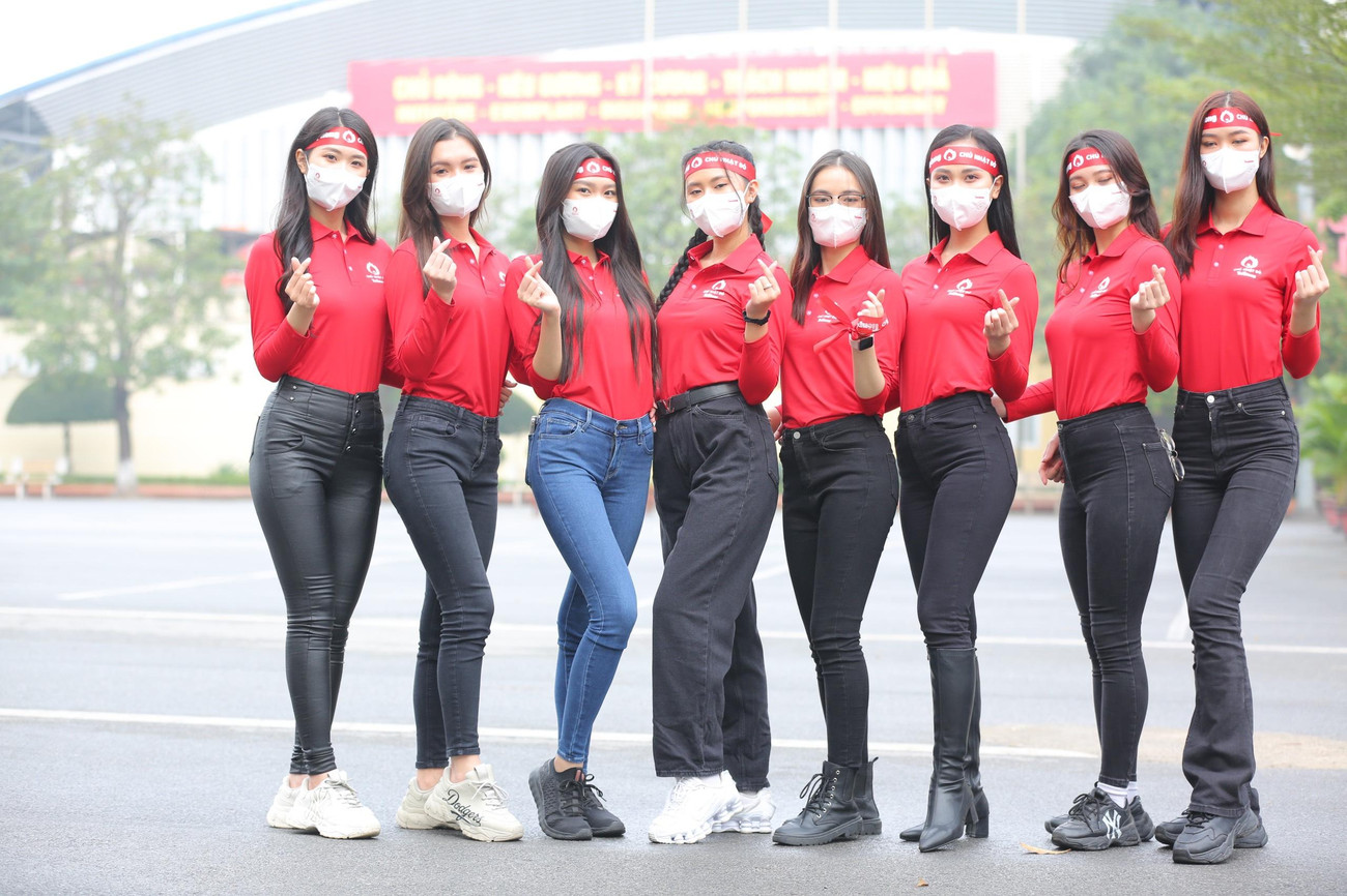 Các người đẹp mặc đồng phục đỏ rực của sự kiện Chủ nhật Đỏ, khoe dáng tại Học viện Cảnh sát Nhân dân sau khi đi cùng đoàn diễu hành tới địa điểm tổ chức của ngày hội chính năm nay.