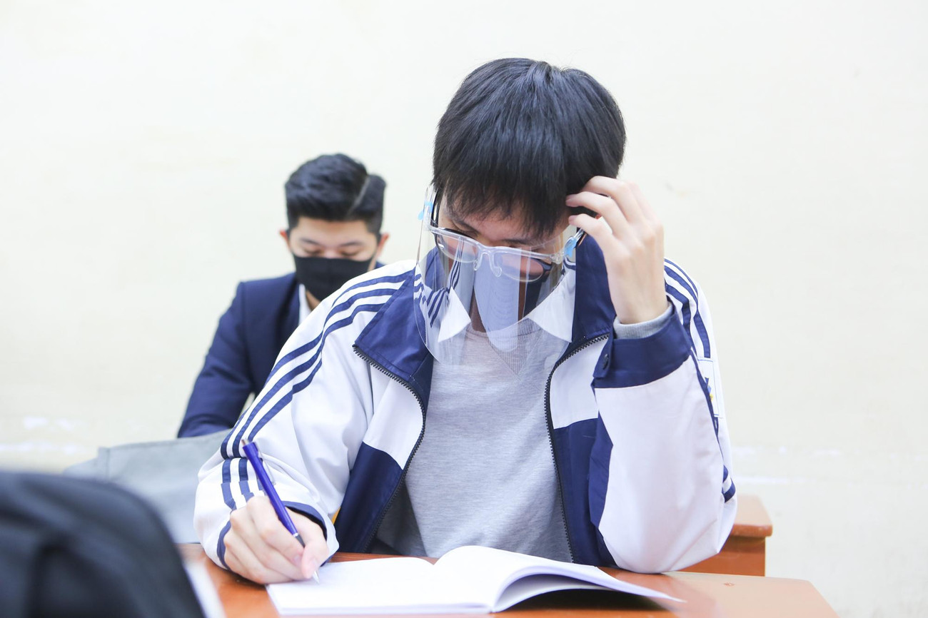 Một số bạn học sinh cẩn thận đeo cả kính chắn giọt bắn trong lớp học.