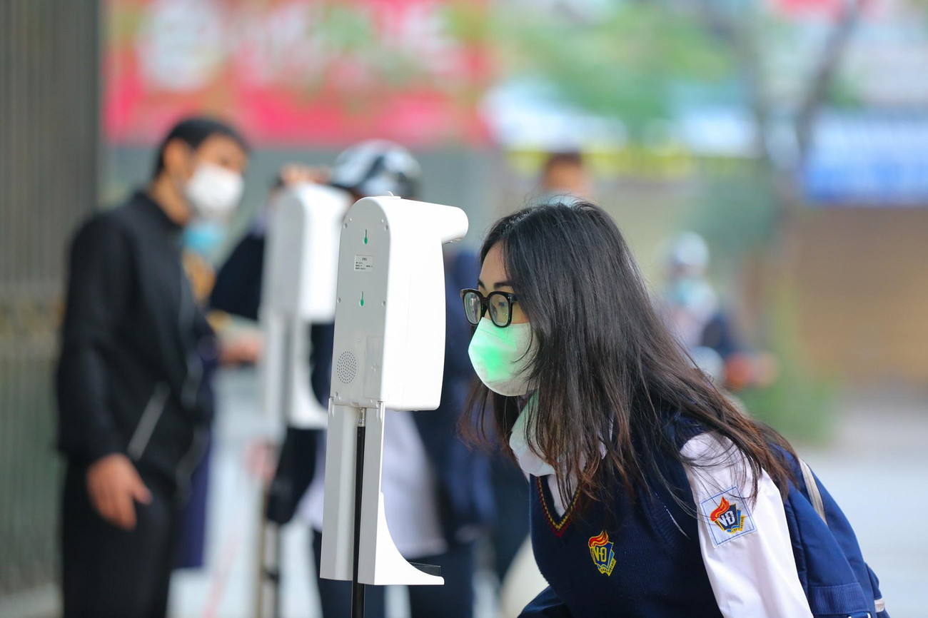 Tại cổng trường, giáo viên sẽ hướng dẫn học sinh di chuyển theo đúng làn, đo thân nhiệt, sát khuẩn và giữ khoảng cách.