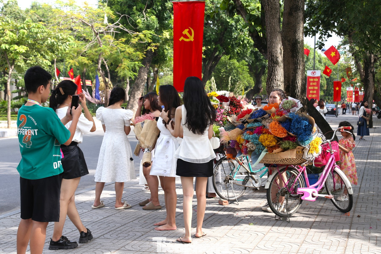 Ghi nhận sáng 2/9, có rất đông bạn trẻ có mặt tại đây để chụp ảnh, lưu giữ khoảnh khắc đẹp bên những gánh hoa rực rỡ. Khách đông đến độ một gánh hoa có 10 "nàng thơ" tạo dáng chụp ảnh.