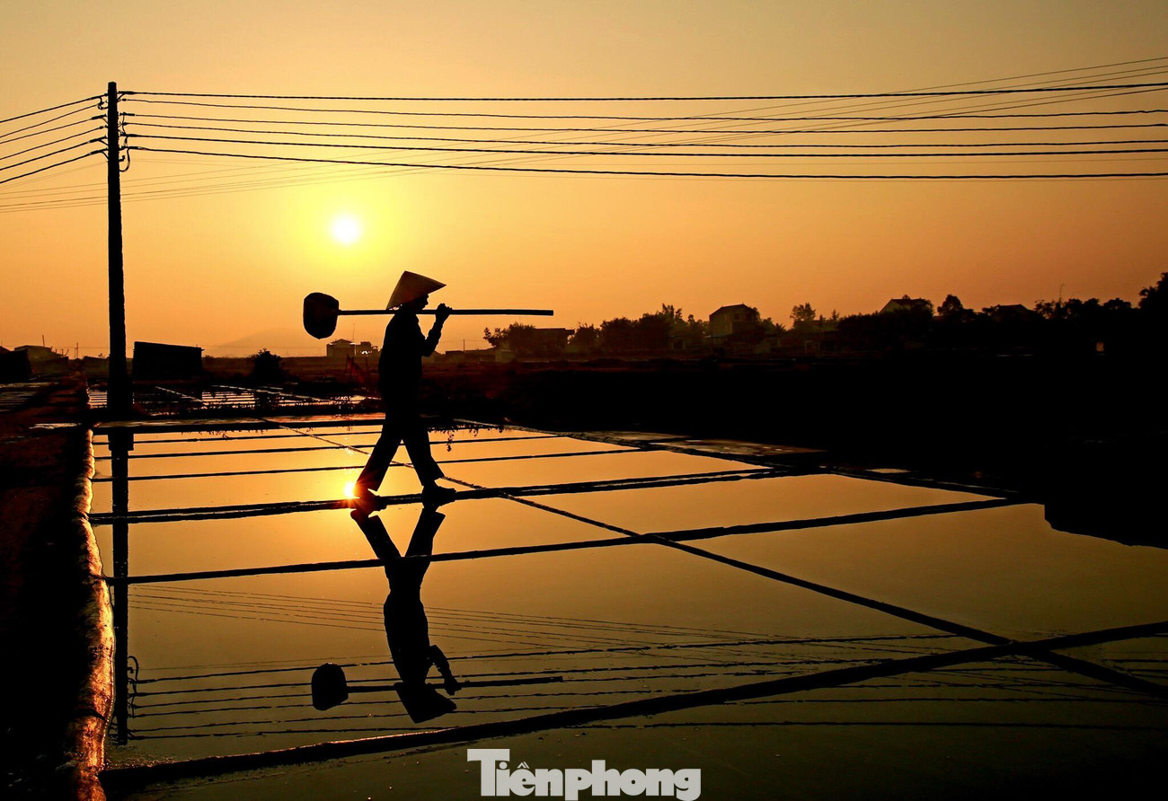 Một ngày của diêm dân xã An Hòa (huyện Quỳnh Lưu, Nghệ An) bắt đầu từ sáng tinh mơ, khi những tia nắng đầu tiên của ngày mới còn e ấp sau những mái nhà. Từng tốp người đội nón lá, vai mang quang gánh, tay xách bồ cào rộn ràng ra cánh đồng muối.