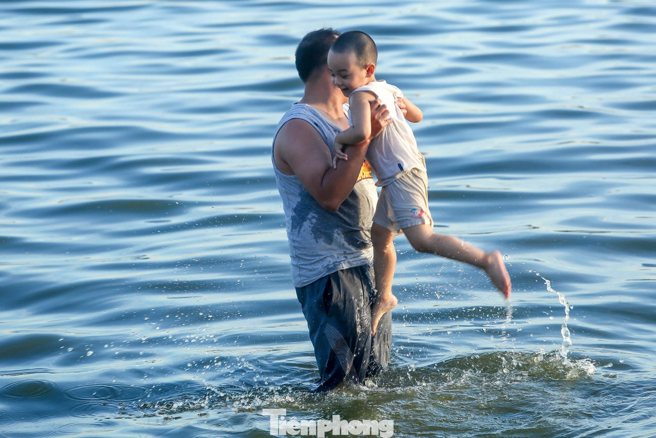 Hai cha con vui chơi dưới làn nước hồ Tây