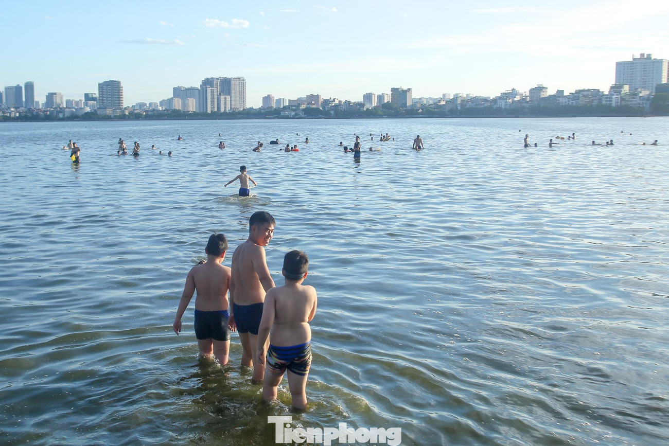 Hồ Tây không chỉ là nơi hóng mát mà còn là một “bể bơi” khổng lồ để người dân bơi lội trong những ngày nắng nóng gay gắt.