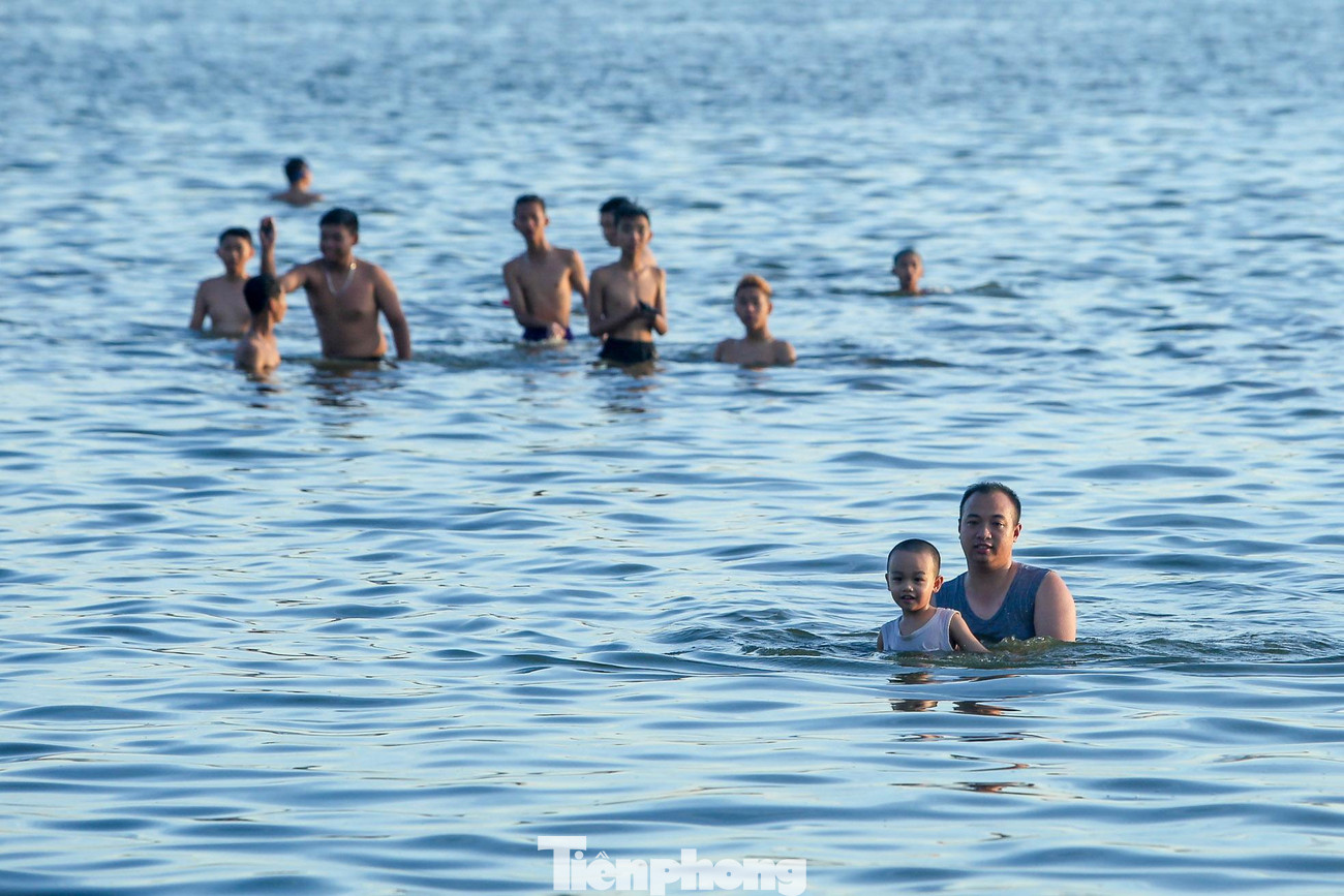 "Nhà tôi ngay gần đây nên đưa cháu ra đây tắm luôn, gần bờ thì hơi bẩn nhưng ra giữa hồ nước rất sạch và trong, hồ cũng không sâu nên có thể tắm thoải mái thay vì đến bể bơi", một người dân tắm ở đây chia sẻ.