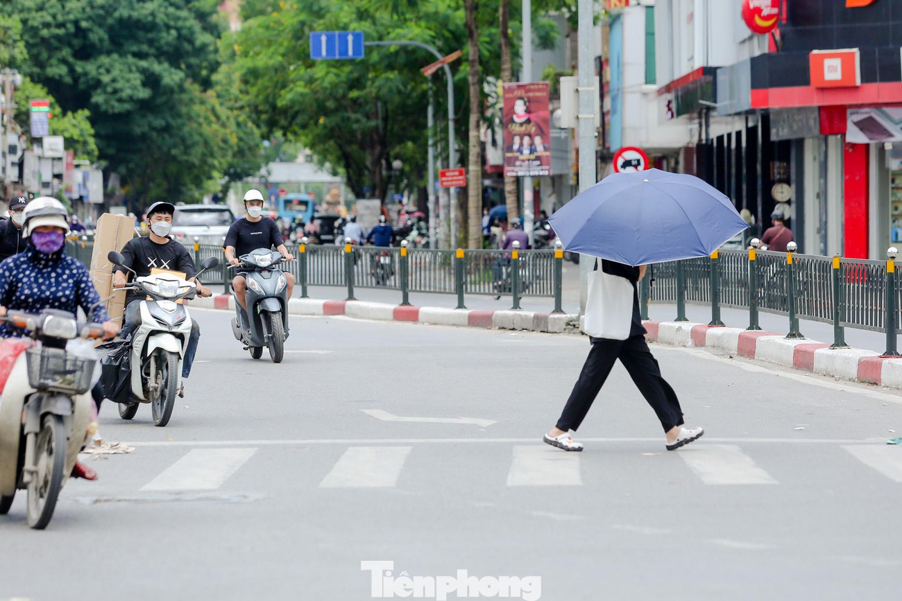 Người đi bộ mang theo ô chống nắng.