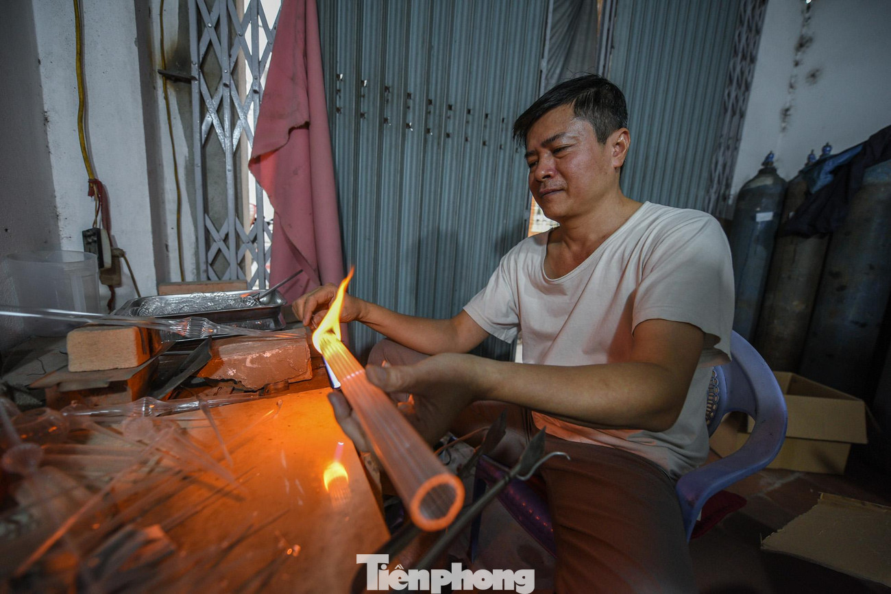 Ông Lương Văn Trãi- người đã có hơn 25 năm với nghề thủy tinh, miệt mài trong xưởng để làm mẻ dụng cụ y tế bằng thủy tinh.